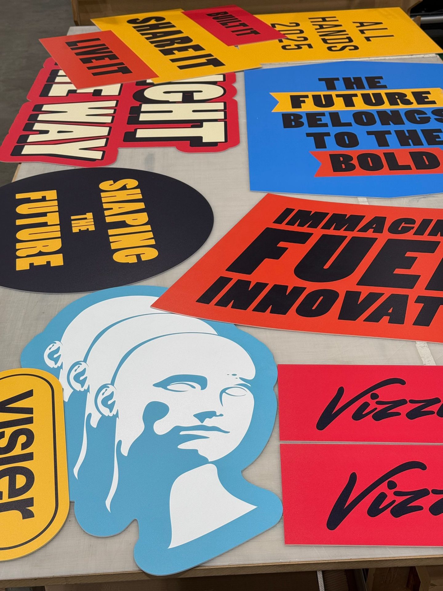 Assorted Visier event signage cutouts with bold text and branding elements prepared for installation.