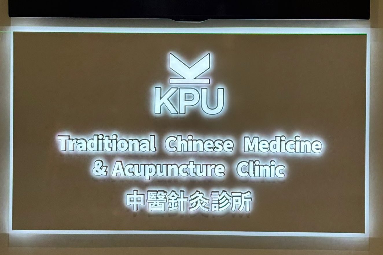 Illuminated bilingual wall-mounted signage for KPU Traditional Chinese Medicine & Acupuncture Clinic.