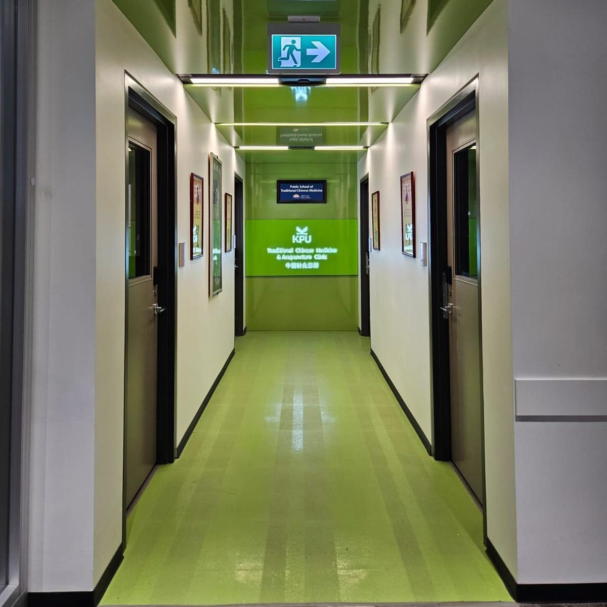 Interior hallway view with illuminated KPU Traditional Chinese Medicine Clinic signage at corridor entrance.